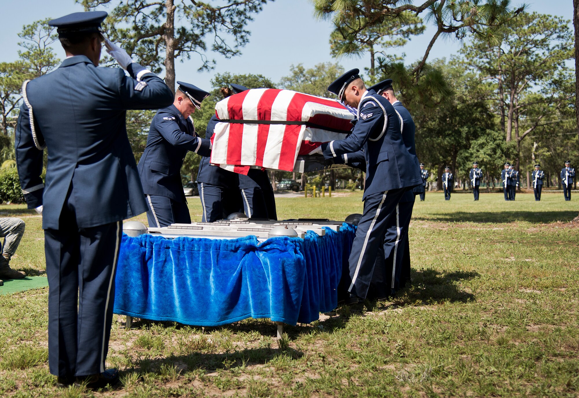 Senior Airman Benjamin Dela Rosa salutes as Honor Guard members set the casket down at their graduation ceremony June 15 at Eglin Air Force Base, Fla. Approximately 12 new Airmen graduated from the 80-plus-hour course. The graduation performance includes flag detail, rifle volley, pall bearers and bugler for friends, family and unit commanders. (U.S. Air Force photo/Samuel King Jr.)