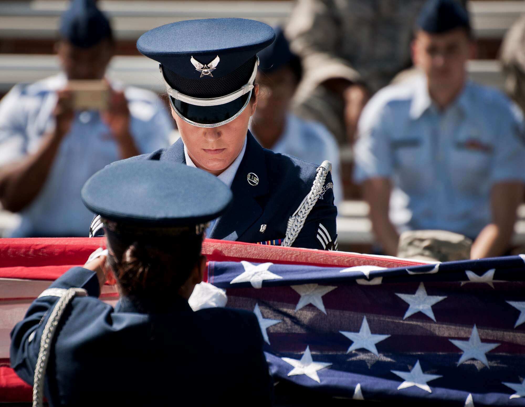 Senior Airman Christen Neel flattens out the flag during an Honor Guard graduation ceremony June 15 at Eglin Air Force Base, Fla. Approximately 12 new Airmen graduated from the 80-plus-hour course. The graduation performance includes flag detail, rifle volley, pall bearers and bugler for friends, family and unit commanders. (U.S. Air Force photo/Samuel King Jr.)