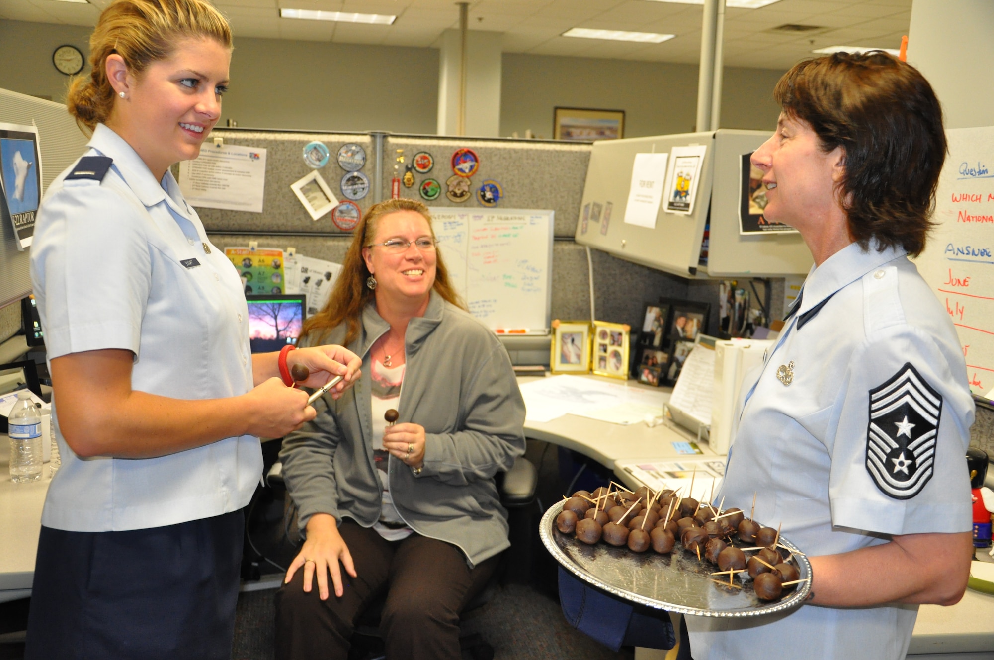 Chief Master Sgt. Doreen Losacco, Air Force Life Cycle Management Center command chief, shares homemade cake pops with 1st Lt. Caitlin Smart and Tina Compton, both with the F-22 Division, and talks to them about their projects (Air Force photo by Gina Marie Giardina)