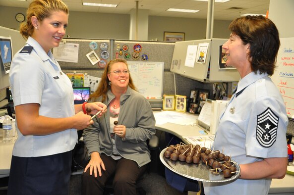 Chief Master Sgt. Doreen Losacco, Air Force Life Cycle Management Center command chief, shares homemade cake pops with 1st Lt. Caitlin Smart and Tina Compton, both with the F-22 Division, and talks to them about their projects (Air Force photo by Gina Marie Giardina)