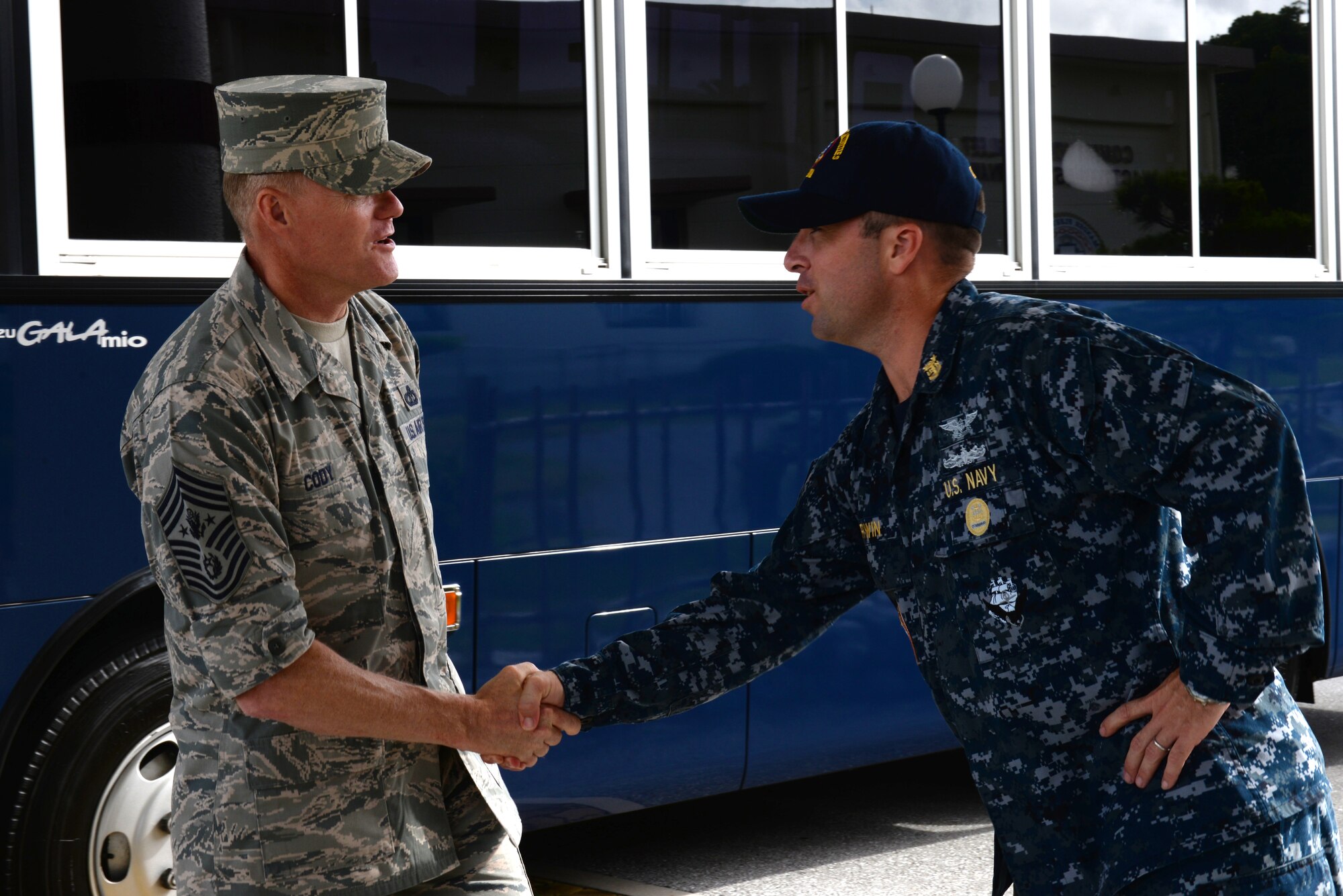 Chief Master Sgt. of the Air Force James Cody is greeted by Command Master Cheif Daniel Irwin,  CMC of Commander Fleet Activities Okinawa , on Kadena Air Base, Japan, July 6, 2015. While on Kadena, Cody spoke face-to-face with enlisted personnel that made up Team Kadena. (U.S. Air Force photo by Senior Airman Omari Bernard)