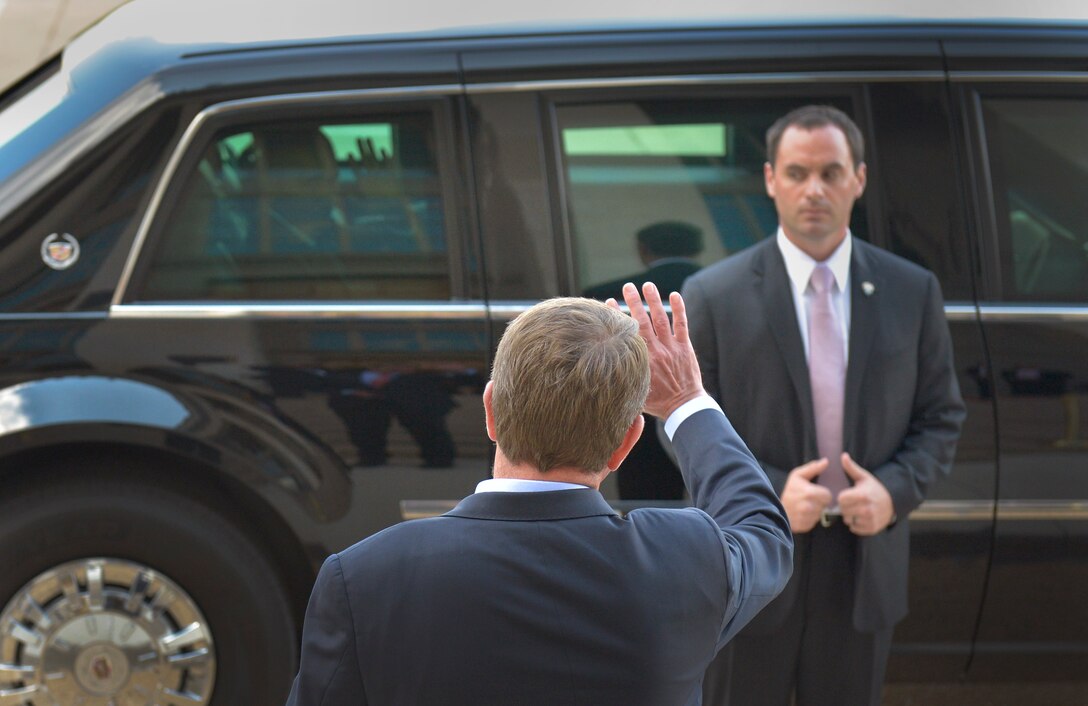 Defense Secretary Ash Carter waves as President Barack Obama departs, following a visit to the Pentagon, July 6, 2015. Obama met with Carter and his national security team and hosted a news conference with reporters.
