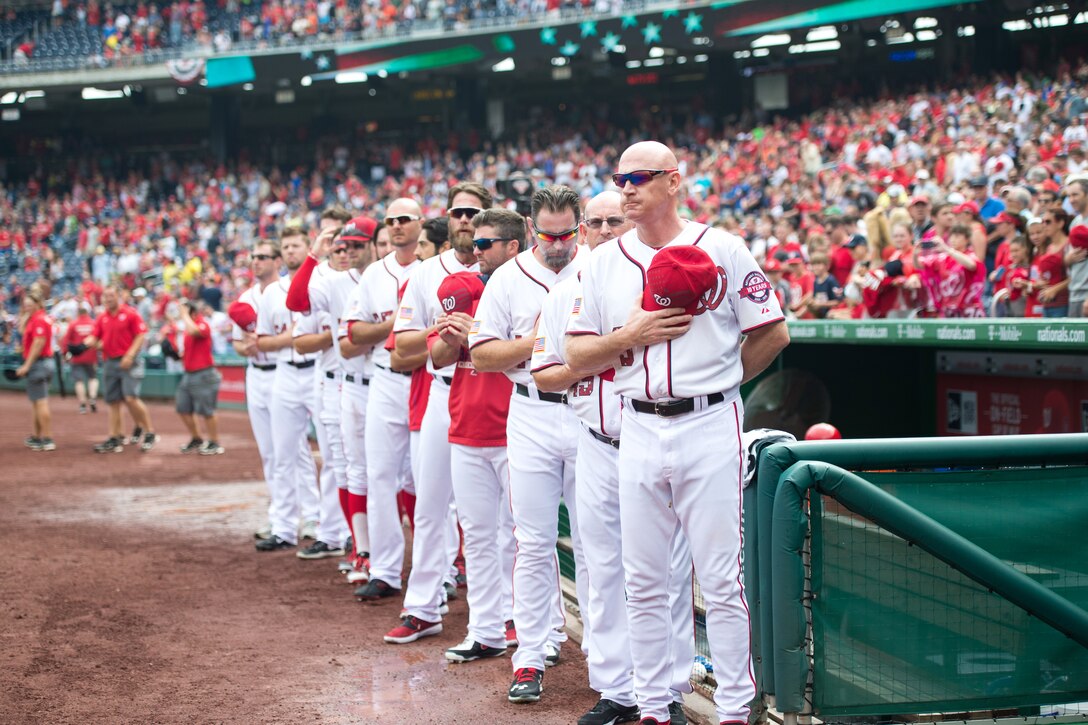 Matt Williams, coach of the Washington Nationals Major League baseball team and player render honors during the playing of the national anthem before the baseball game against the San Francisco Giants at Nationals Park in Washington, D.C., July 4, 2015.