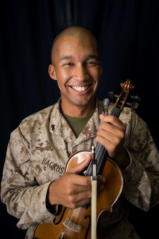 U.S. Marine Cpl. Joshua Backus poses for photos with his violin aboard the dock landing ship USS Rushmore (LSD 47). Backus is a radio technician with Headquarters and Service Company, Battalion Landing Team 3rd Battalion, 1st Marine Regiment, 15th Marine Expeditionary Unit. Music has influenced Backus to master any task he takes on and uses it to inspire others on ship to do the same. The 15th MEU is embarked on the Essex Amphibious Ready Group and deployed to maintain regional security in the U.S. 5th Fleet area of operations. (U.S. Marine Corps photo by Sgt. Emmanuel Ramos/Released)