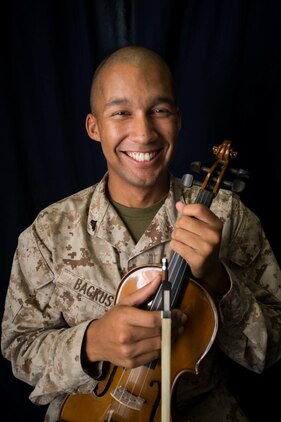 U.S. Marine Cpl. Joshua Backus poses for photos with his violin aboard the dock landing ship USS Rushmore (LSD 47). Backus is a radio technician with Headquarters and Service Company, Battalion Landing Team 3rd Battalion, 1st Marine Regiment, 15th Marine Expeditionary Unit. Music has influenced Backus to master any task he takes on and uses it to inspire others on ship to do the same. The 15th MEU is embarked on the Essex Amphibious Ready Group and deployed to maintain regional security in the U.S. 5th Fleet area of operations. (U.S. Marine Corps photo by Sgt. Emmanuel Ramos/Released)