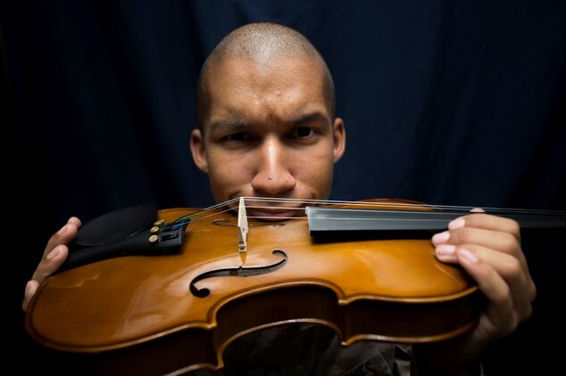 U.S. Marine Cpl. Joshua Backus poses for photos with his violin aboard the dock landing ship USS Rushmore (LSD 47). Backus is a radio technician with Headquarters and Service Company, Battalion Landing Team 3rd Battalion, 1st Marine Regiment, 15th Marine Expeditionary Unit. Music has influenced Backus to master any task he takes on and uses it to inspire others on ship to do the same. The 15th MEU is embarked on the Essex Amphibious Ready Group and deployed to maintain regional security in the U.S. 5th Fleet area of operations. (U.S. Marine Corps photo by Sgt. Emmanuel Ramos/Released)