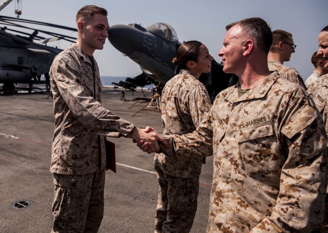 U.S. Marine Sgt. Taylor Bukoski, left, 15th Marine Expeditionary Unit, shakes hands with Lt. Col. James Fallon, after his promotion ceremony aboard the amphibious assault ship USS Essex (LHD 2). Fallon is the executive officer for the 15th MEU. The 15th MEU is embarked on the Essex Amphibious Ready Group and deployed to maintain regional security in the U.S. 5th Fleet area of operations. (U.S. Marine Corps photo by Cpl. Elize McKelvey/ Released)