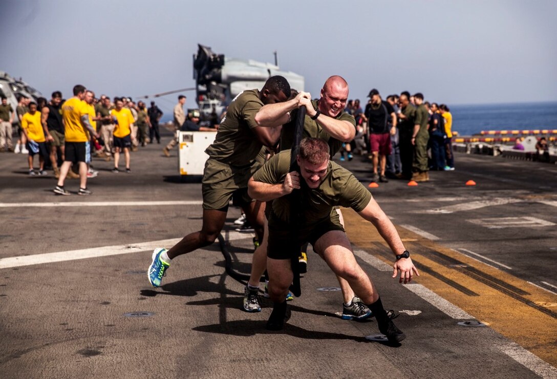 U.S. Marines with the 15th Marine Expeditionary Unit participate in a “tractor pull” competition on the flight deck of the amphibious assault ship USS Essex (LHD 2). The event builds unit morale among the 15th MEU and with Sailors from the Essex Amphibious Ready Group. The 15th MEU is embarked on the Essex Amphibious Ready Group and deployed to maintain regional security in the U.S. 5th Fleet area of operations. (U.S. Marine Corps photo by Cpl. Elize McKelvey/ Released)
