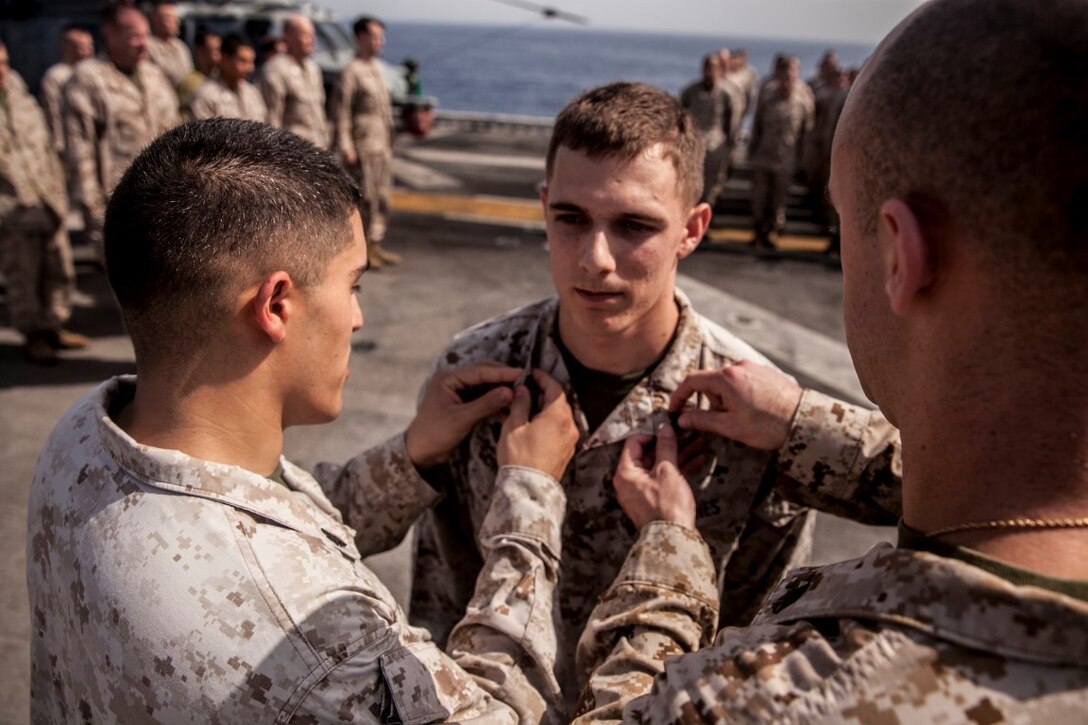 U.S. Marine Sgt. Anthony Scholeno is pinned by his fellow Marines from the 15th Marine Expeditionary Unit during a promotion ceremony aboard the amphibious assault ship USS Essex (LHD 2). The 15th MEU is embarked on the Essex Amphibious Ready Group and deployed to maintain regional security in the U.S. 5th Fleet area of operations. (U.S. Marine Corps photo by Cpl. Elize McKelvey/ Released)