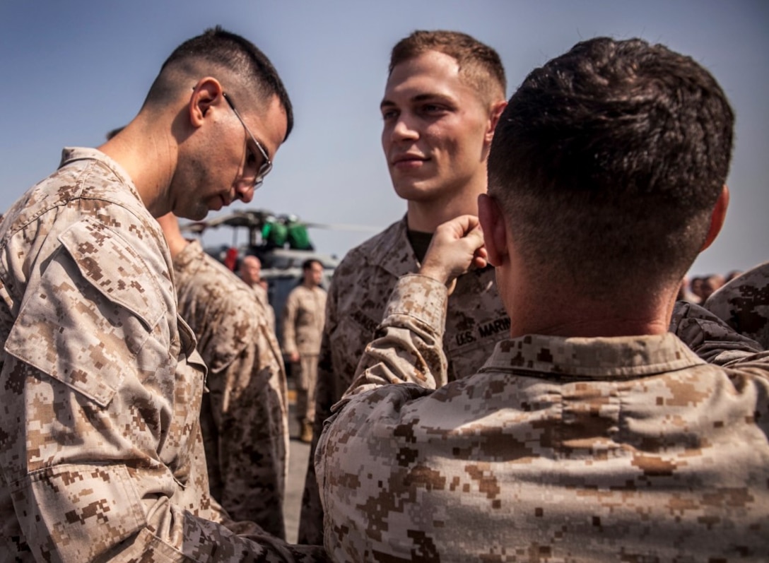 U.S. Marine Sgt. Taylor Bukoski is pinned by his fellow Marines from the 15th  Marine Expeditionary Unit during a promotion ceremony aboard the amphibious assault ship USS Essex (LHD 2). The 15th MEU is embarked on the Essex Amphibious Ready Group and deployed to maintain regional security in the U.S. 5th Fleet area of operations. (U.S. Marine Corps photo by Cpl. Elize McKelvey/ Released)