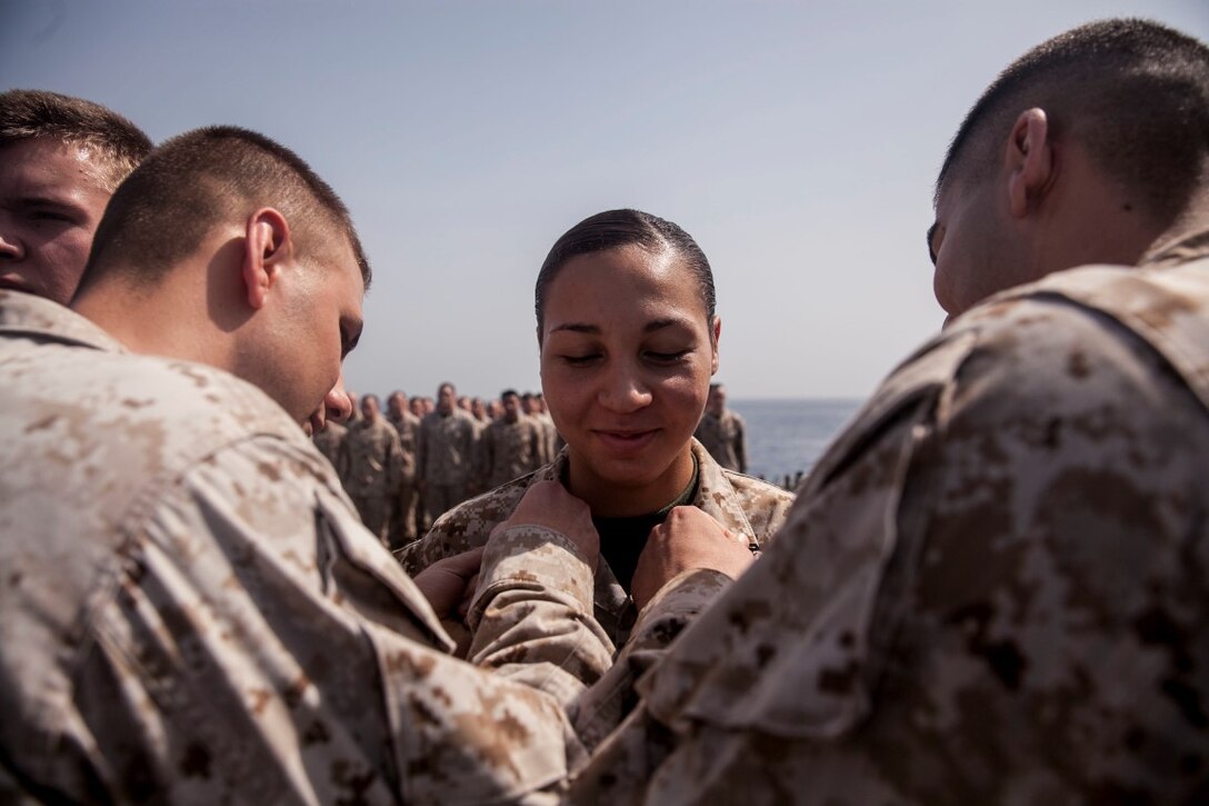 U.S. Marine Cpl. Justine Orr is pinned by her fellow Marines from the 15th Marine Expeditionary Unit during a promotion ceremony aboard the amphibious assault ship USS Essex (LHD 2). The 15th MEU is embarked on the Essex Amphibious Ready Group and deployed to maintain regional security in the U.S. 5th Fleet area of operations. (U.S. Marine Corps photo by Cpl. Elize McKelvey/ Released)