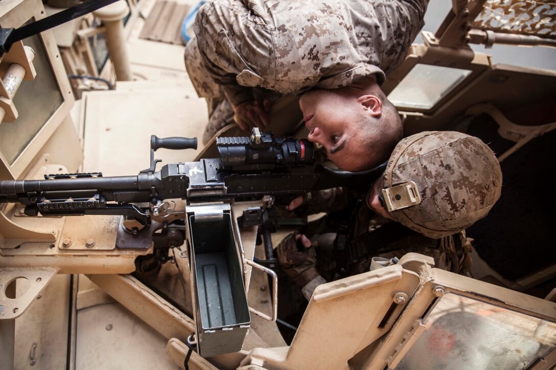 U.S. Marine Cpl. Ryan Reardon, left, checks to see if Lance Cpl. Jamie Camacho is aimed in on his target during mounted-weapons drills aboard the dock landing ship USS Rushmore (LSD 47). Camacho is an automatic rifleman with Kilo Company, Battalion Landing Team 3rd Battalion, 1st Marine Regiment, 15th Marine Expeditionary Unit. During the training, Marines rehearsed mounting and dismounting the M240B, reload drills, and engaging multiple targets. The 15th MEU is embarked on the Essex Amphibious Ready Group and deployed to maintain regional security in the U.S. 5th Fleet area of operations. (U.S. Marine Corps photo by Sgt. Emmanuel Ramos/Released)