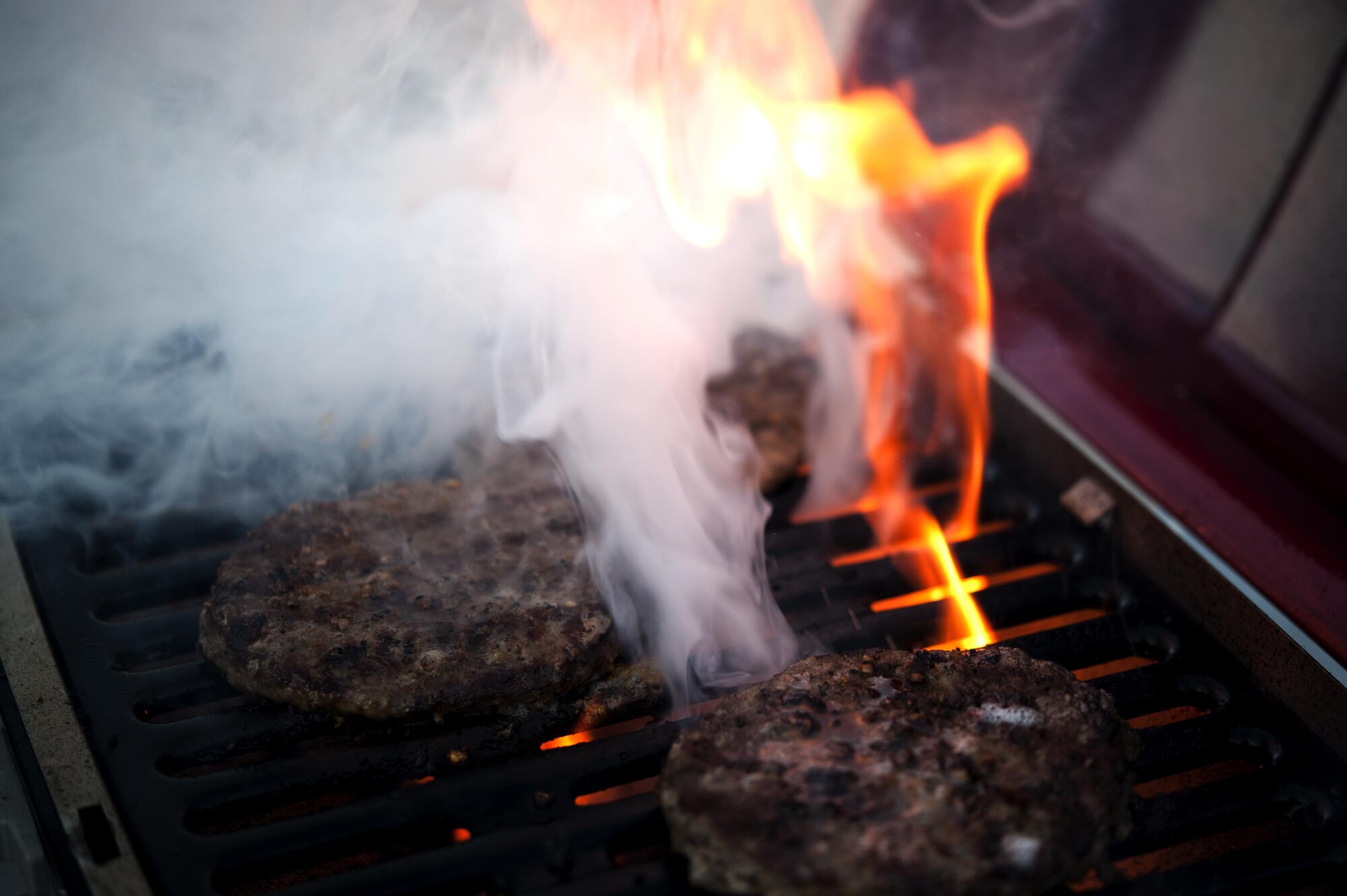 A grill flairs up while burgers cook during the 4th of July party at the Goodfellow Recreational Camp, Texas, July 4, 2015. During the celebration, team Goodfellow members enjoyed barbeque, live music and fireworks. (U.S. Air Force photo by Senior Airman Scott Jackson/Released)