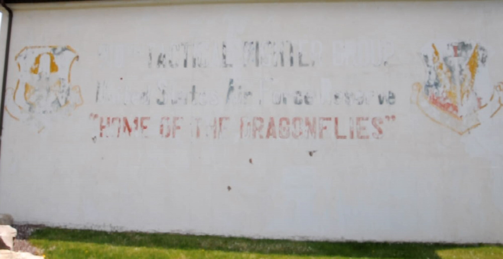 An exterior wall of building 307, a deluge pump house for aircraft hangars here, displays weathered artwork for the 910th Tactical Fighter Group, stationed here from 1971 to 1981. The artwork was uncovered while workers pressure-washed the building May, 2015. The 910th Tactical Fighter Group flew the A-37 Dragonfly. U.S. Air Force photo/Tech. Sgt. Jim Brock.