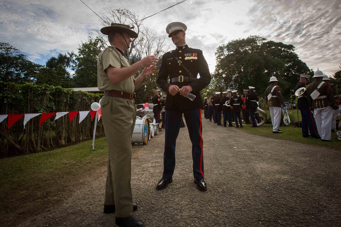 Chief Warrant Officer 3 Bryan P. Sherlock, U.S. Marine Corps Forces Pacific Band Officer, talks with the Australian Army Band officer before the Coronation Celebration Parade in Nuku'alofa, Tonga, July 4, 2015. The MARFORPAC Band travels throughout the Pacific region to promote community relations and interoperability between the U.S. and other countries. 