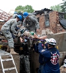 Members of the Indiana 53rd Civil Support Team assist the  Indiana Department of Homeland Security, District 2, Tactical Rescue Team from  South Bend, Indiana, pull a mock victim from the rubble during National Level  Exercise 2011, a full-scale exercise meant to represent the destruction  following a 7.7 magnitude earthquake along the New Madrid fault line. The  exercise, taking place at Muscatatuck Urban Training Complex May 16 - 20, will  examine the government's ability to implement local, state, and federal catastrophic  earthquake response plans.