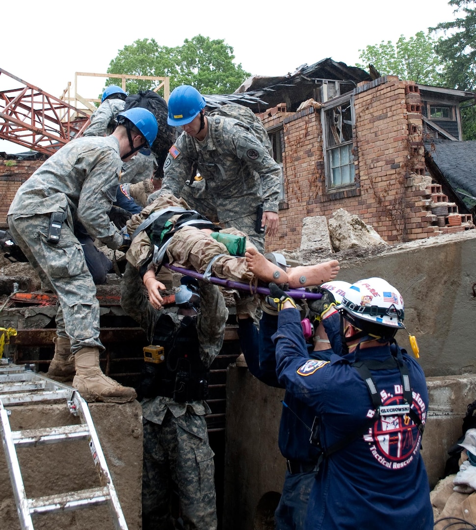 Members of the Indiana 53rd Civil Support Team assist the  Indiana Department of Homeland Security, District 2, Tactical Rescue Team from  South Bend, Indiana, pull a mock victim from the rubble during National Level  Exercise 2011, a full-scale exercise meant to represent the destruction  following a 7.7 magnitude earthquake along the New Madrid fault line. The  exercise, taking place at Muscatatuck Urban Training Complex May 16 - 20, will  examine the government's ability to implement local, state, and federal catastrophic  earthquake response plans.