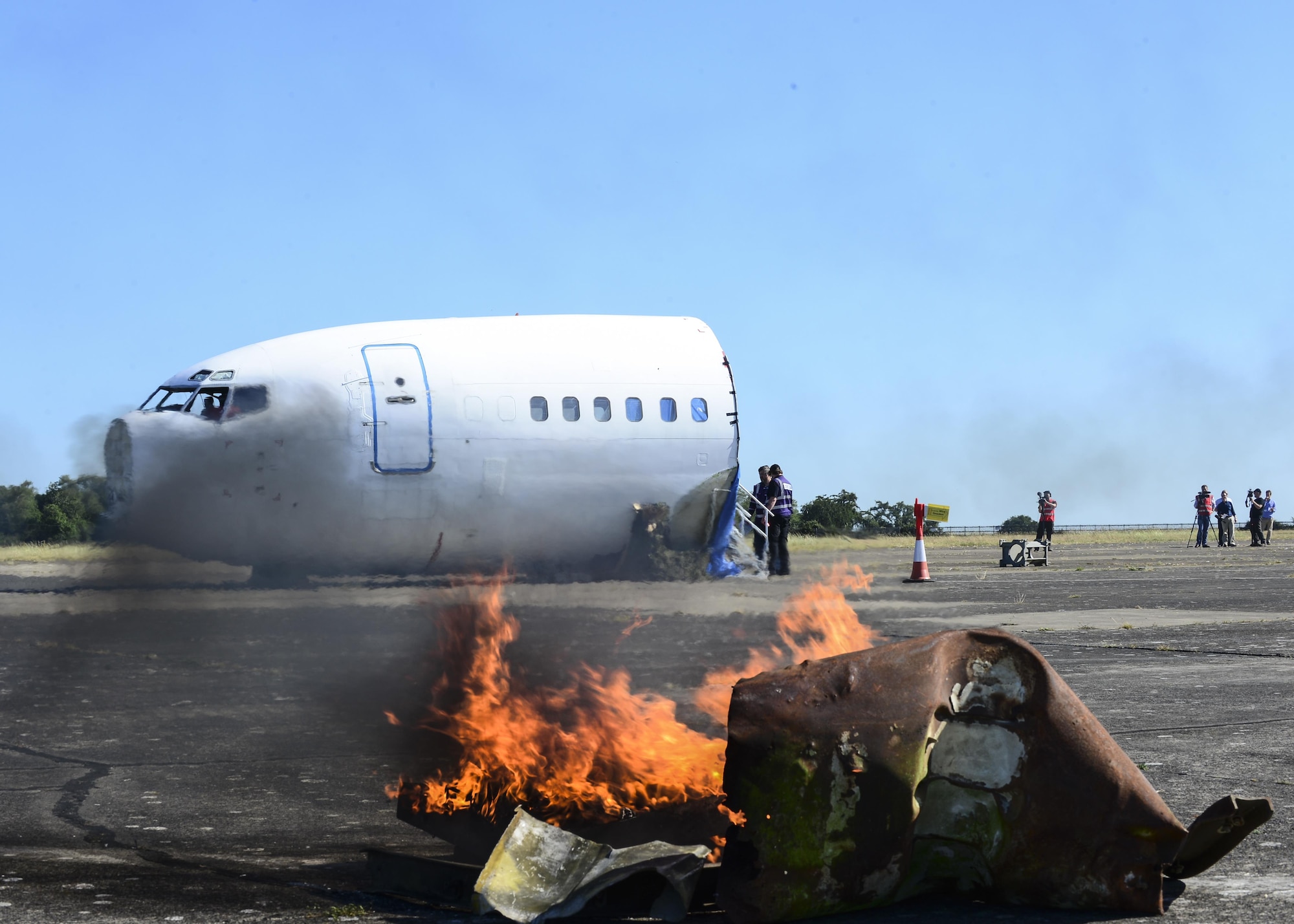 Fiery debris and a simulated aircraft crash cover the flightline during exercise Diamond Dragon at Royal Air Force Honington, England, June 30, 2015. Diamond Dragon is a three-day joint forces response exercise that readies members of the U.K. Ministry of Defence, emergency response agencies and the U.S. Air Force for incidents that require help from both nations. (U.S. Air Force photo/Senior Airman Nigel Sandridge)