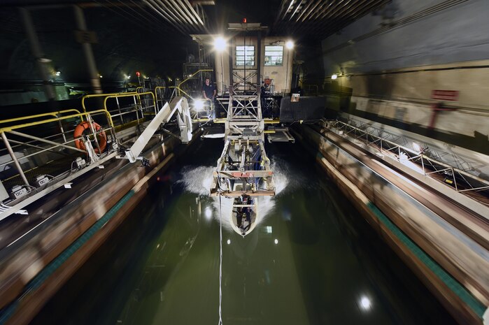 150406-N-PO203-199 
WEST BETHESDA, Md. (April 3, 2015) A ship hull model attached to a high-speed sled moves through waves at the David Taylor Model Basin at Naval Surface Warfare Center, Carderock, during Office of Naval Research -sponsored research. The research studies the fundamental physics of the water-impact of high-speed planing hulls and to measure the slamming loads and resulting motions of the craft upon re-entry into the water. (U.S. Navy photo by John F. Williams/Released)                                                                                                            