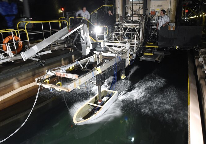 150403-N-PO203-077 
WEST BETHESDA, Md. (April 3, 2015) A ship hull model attached to a high-speed sled moves through waves at the David Taylor Model Basin at Naval Surface Warfare Center, Carderock, during Office of Naval Research -sponsored research. The research studies the fundamental physics of the water-impact of high-speed planing hulls and to measure the slamming loads and resulting motions of the craft upon re-entry into the water. (U.S. Navy photo by John F. Williams/Released)                                                                                                            