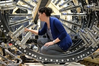 141015-N-AP853-002 WEST BETHESDA, Md. (Oct. 15, 2014) Jessica McElman, an electrical engineer at Naval Surface Warfare Center, Carderock Division, adjusts a magnetic field sensor in the model track located in the Magnetic Fields Laboratory in West Bethesda, Md. (U.S. Navy photo by Nicholas Malay/Released)