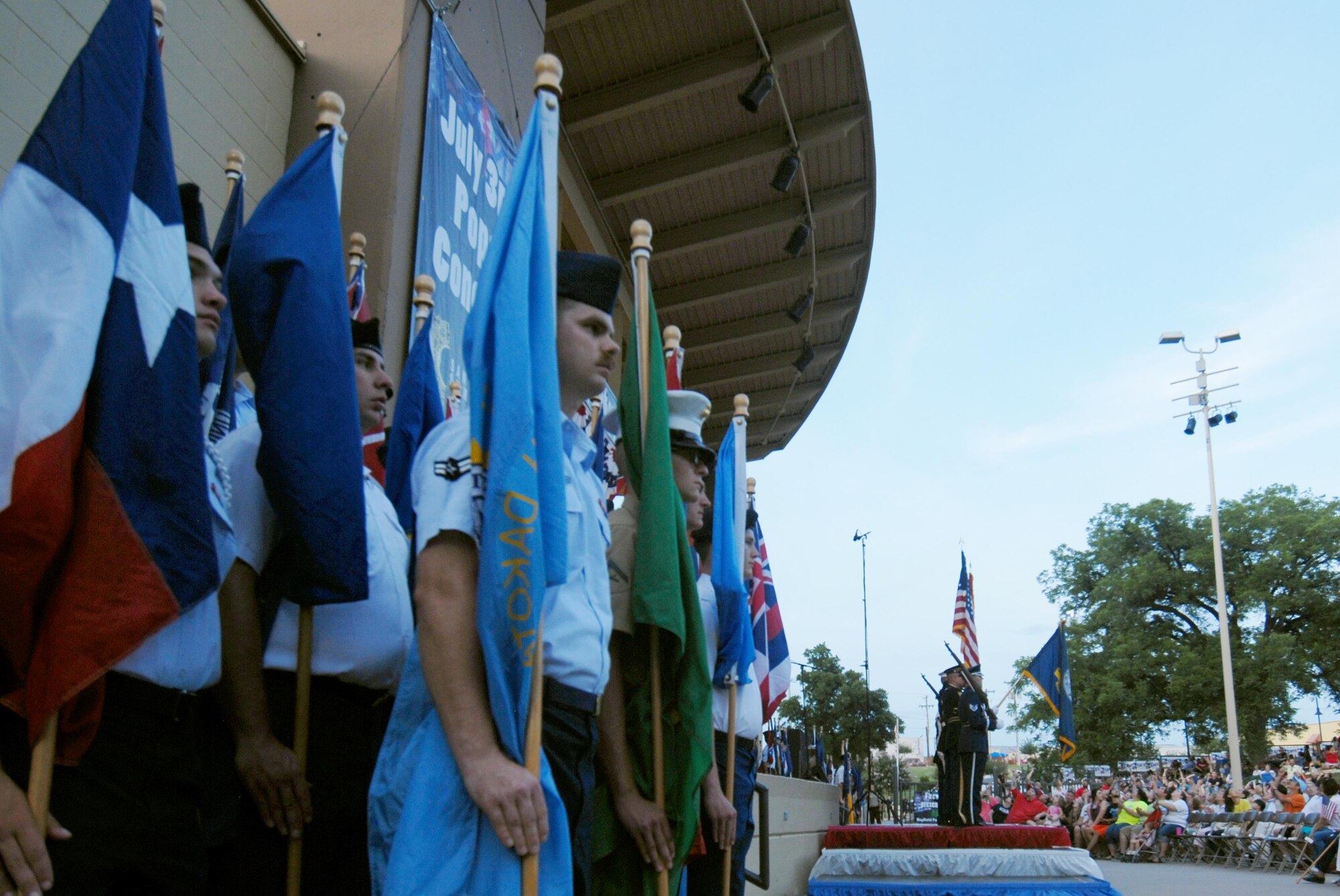 Goodfellow Air Force Base service members stand at attention while the base color guard presents the different services flags during the San Angelo Symphony’s Pops Concert at the Bill Aylor Sr. Memorial RiverStage in San Angelo, Texas, July 3, 2015. While the service members presented the flags, the San Angelo Symphony played “A Salute to the Armed Forces.”(U.S. Air Force photo by Senior Airman Joshua Edwards/Released)