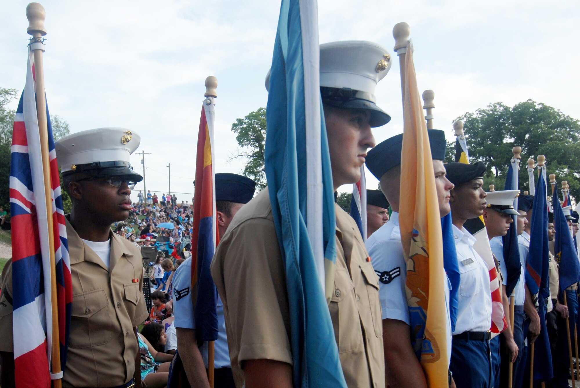 Goodfellow Air Force Base service members wait for their cue to march to the front of the Bill Aylor Sr. Memorial RiverStage during the San Angelo Symphony’s Pops Concert in San Angelo, Texas, July 3, 2015. Base service members assisted at the event by displaying the United States, armed services and states flags, during the concert. (U.S. Air Force photo by Senior Airman Joshua Edwards/Released)