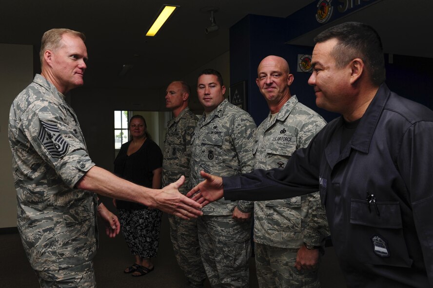 Chief Master Sgt. of the Air Force James Cody shakes hands with Kenichi Shimada, 18th Security Forces Squadron Military Local Contractor program manager, July 6, 2015, at Kadena Air Base, Japan. Cody met with Airmen and MLCs throughout Kadena, as part of his ongoing initiative to engage with Airmen stationed around the globe. (U.S. Air Force photo by Airman 1st Class John Linzmeier/Released)
