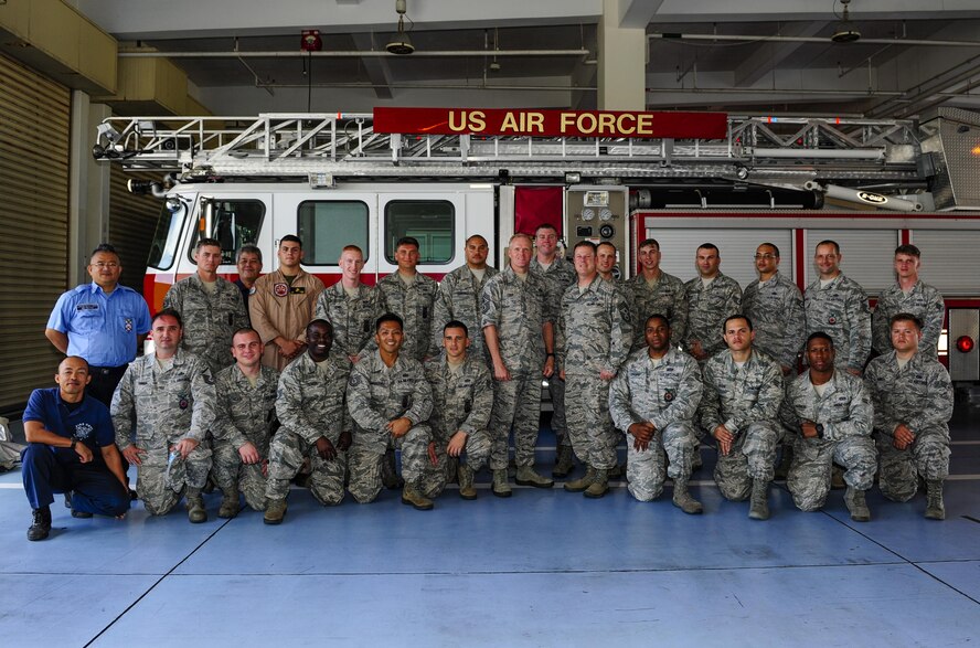 Firefighters from the 18th Civil Engineer Group pose for a photo with Chief Master Sgt. of the Air Force James Cody and Chief Master Sgt. Charles R. Hoffman, 18th Wing command chief, July 6, 2015, at Kadena Air Base, Japan. Cody visited Kadena Airmen to answer questions surrounding changes to the new enlisted evaluation system, promotions, formal training and retirements. (U.S. Air Force photo by Airman 1st Class John Linzmeier/Released)
