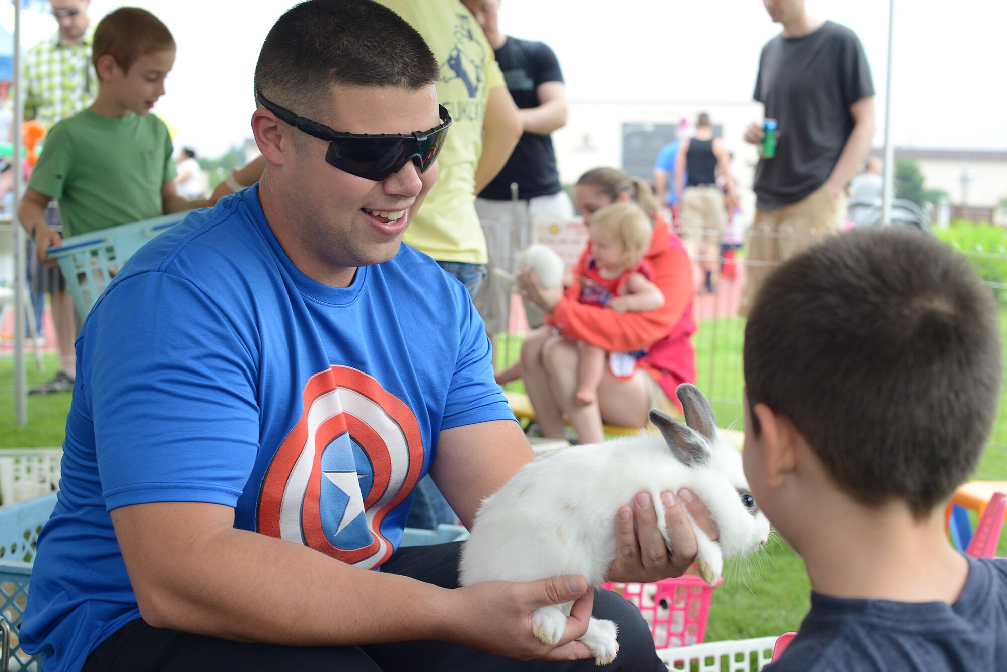 A team Yokota member holds a bunny in a petting zoo during the Celebrate America event at Yokota Air Base, Japan, July 2, 2015. The 374th Force Support Squadron hosted events throughout the day to include a 5k Fun Run, the Leaky Kon Tiki race, go-karts, carnival booths and performances from the Band of the Pacific-Hawaii 'Hana Hou!'. (U.S. Air Force photo by Airman 1st Class David C. Danford/Released)
