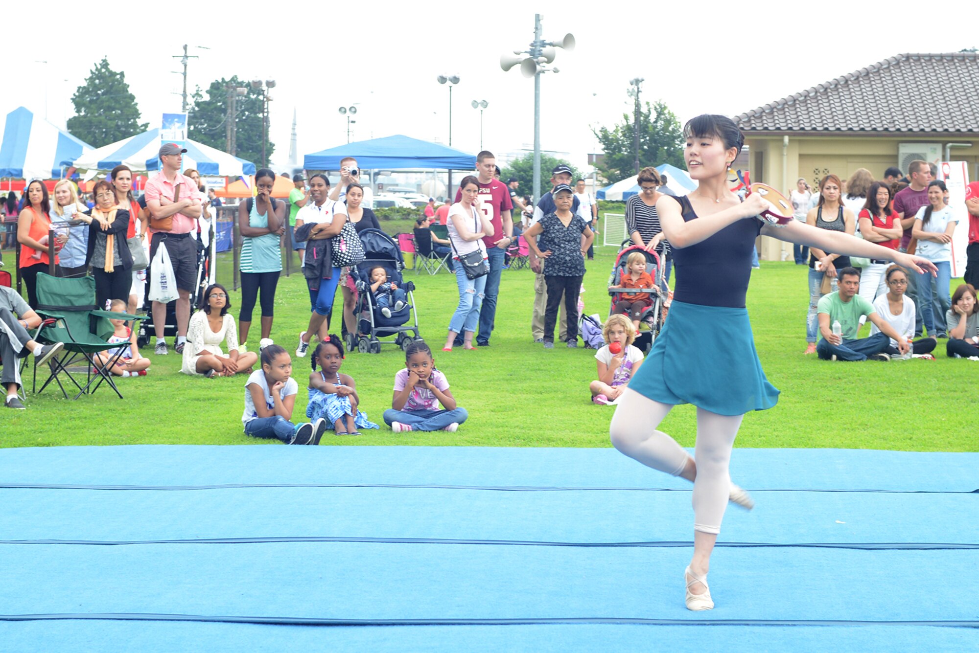 A dancer performs for members of Team Yokota during Celebrate America at Yokota Air Base, Japan, July 2, 2015. The 374th Force Support Squadron hosted events throughout the day to include a 5k Fun Run, the Leaky Kon Tiki race, go-karts, carnival booths and performances from the Band of the Pacific-Hawaii 'Hana Hou!'. (U.S. Air Force photo by Airman 1st Class David C. Danford/Released)