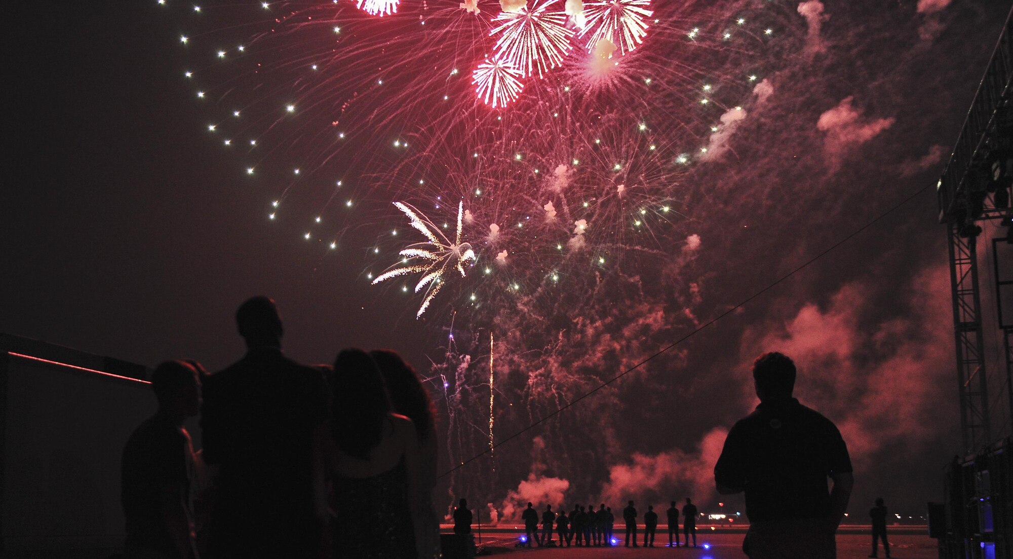 Airmen and entertainers gaze as the fireworks ignite over the skies Osan Air Base, Republic of Korea, July 4, 2015, in celebration of Independence Day. The fireworks presentation was one of the last displays of entertainment for a crowd of more than 5,000 during the festival. (U.S. Air Force photo by Tech. Sgt. Travis Edwards/Released)