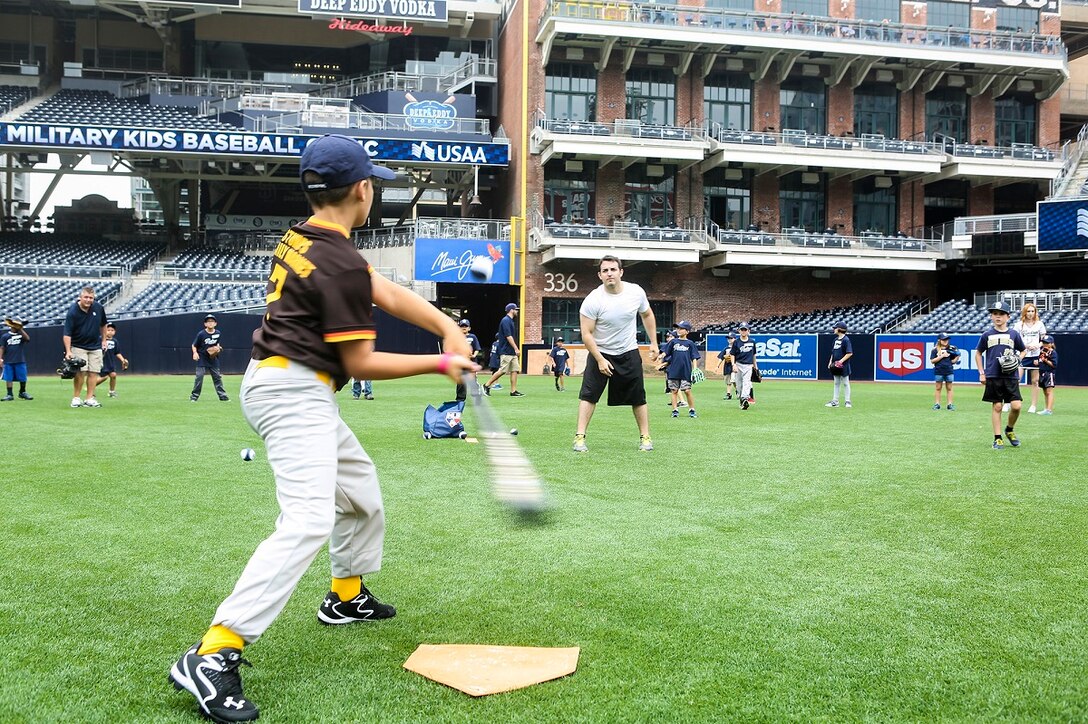 Patrick Coghlan, an intern with the scouting team for the San Diego Padres, tosses a baseball to the son of a servicemember during a Military Kids Baseball Clinic July 2, 2015 in San Diego. Among the children who participated in the event, 50 were dependents of Marines and Sailors currently serving with I Marine Expeditionary Force. The day at the ballpark included batting, pitching and out-fielding drills. The event has taken place three years in a row and is sponsored by the United Services Automobile Association. (Marine Corps Photo by Cpl. Rick Hurtado/Released)
