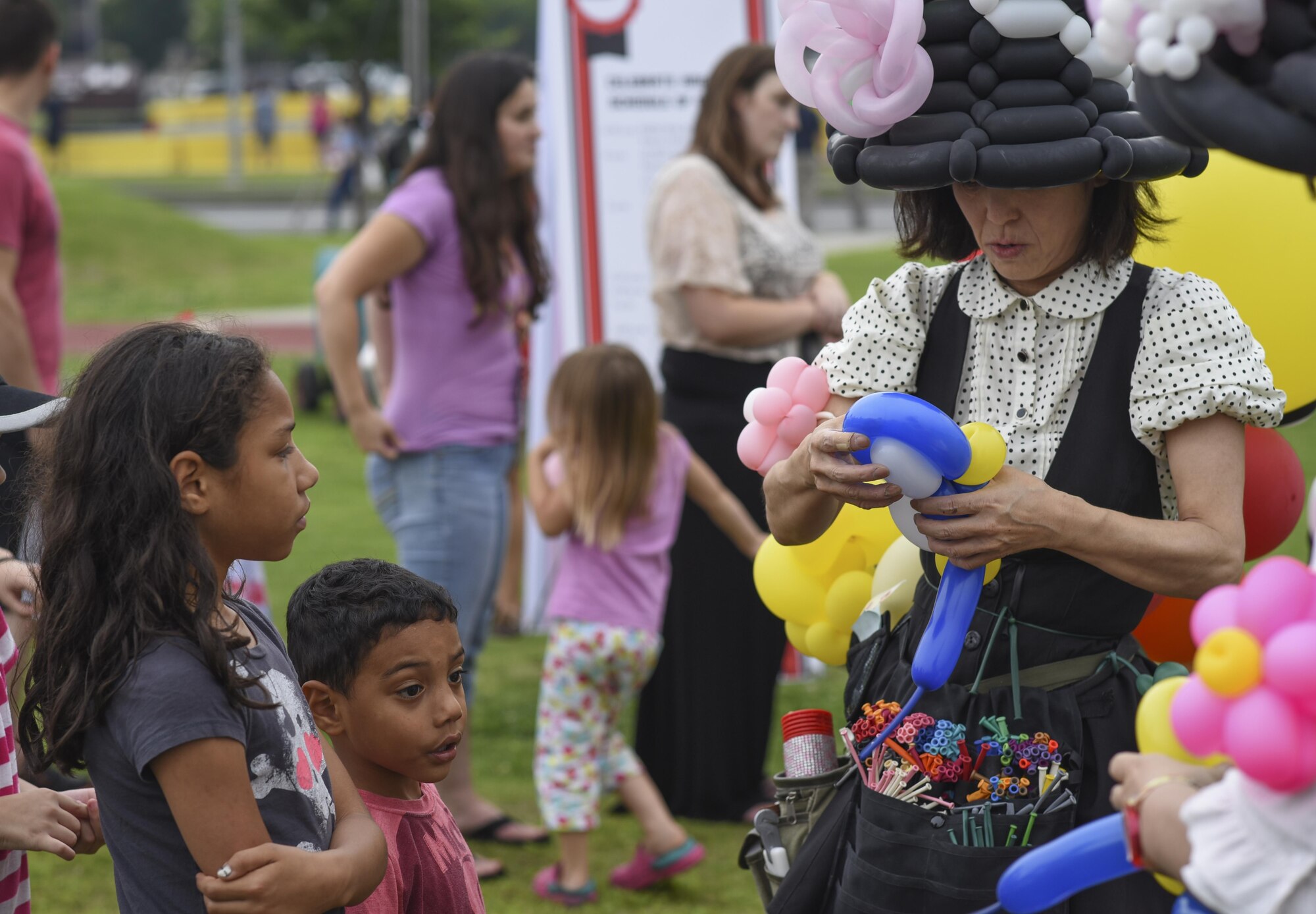 A balloon artist creates a balloon animal for children during Celebrate America at Yokota Air Base, Japan, July 2, 2015. Celebrate America is hosted every year to celebrate America’s Independence Day and enhance esprit de corps. (U.S. Air Force photo by Senior Airman Michael Washburn/Released)