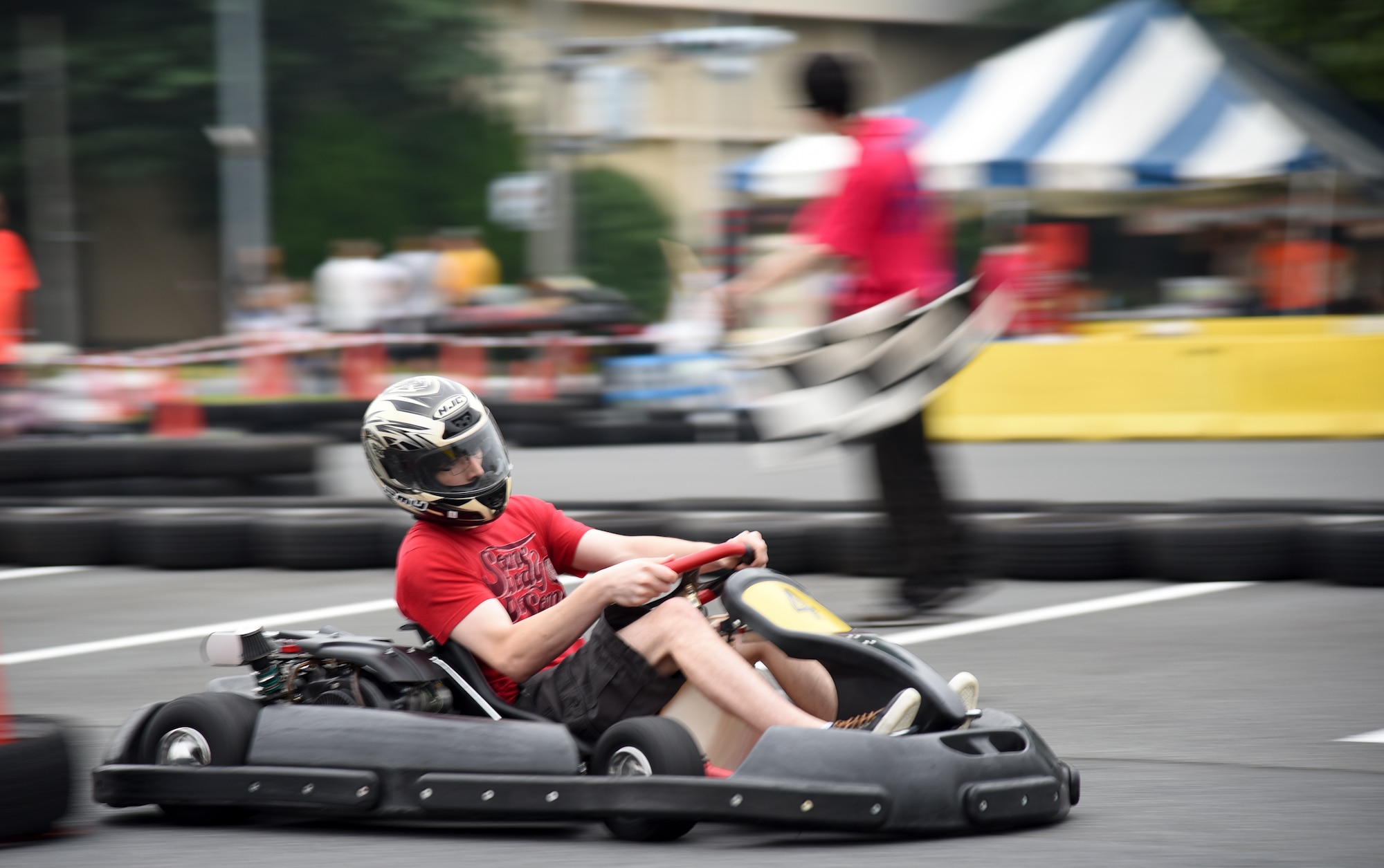 A member of Team Yokota races around the go-kart track during Celebrate America at Yokota Air Base, Japan, July 2, 2015. Some of the events during Celebrate America included live music, a petting zoo, Taiko drummers, dancers and a car show. (U.S. Air Force photo by Senior Airman Michael Washburn/Released)