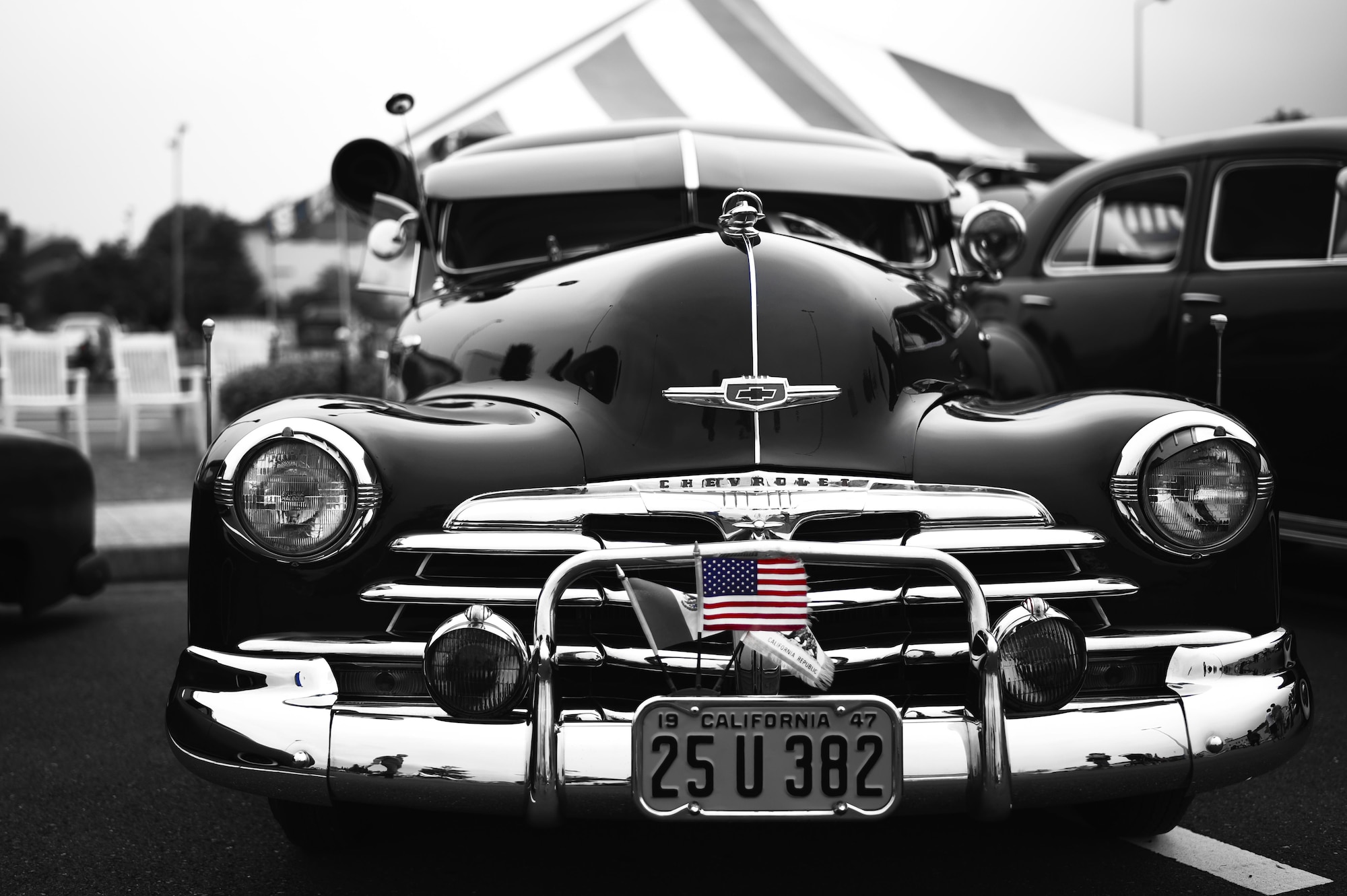 An American flag sticks out of the license plate of a Chevrolet during the car show portion of Celebrate America at Yokota Air Base, Japan, July 2, 2015. Celebrate America brings the spice of traditional Independence Day celebrations to military members stationed overseas at Yokota. (Air Force photo graphic by Senior Airman Michael Washburn/Released)