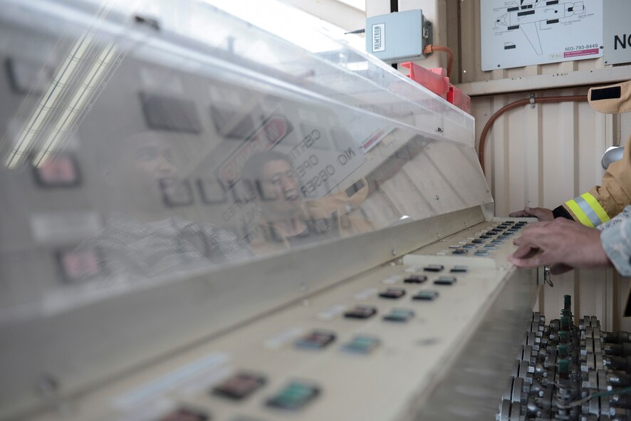 Staff Sgt. Trevor Alexis, 374th Civil Engineer Squadron fire protection NCO in charge of training, runs the gas lines to the fire training pit at Yokota Air Base, Japan, July 7, 2015. The fire training pit allows live-fire training to prepare fire protection members to extinguish engine, running fuel and fuselage fires. (U.S. Air Force photo by Staff Sgt. Cody H. Ramirez/Released)  