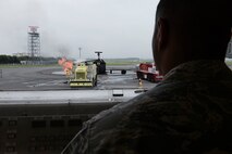 Staff Sgt. Trevor Alexis, 374th Civil Engineer Squadron fire protection NCO in charge of training, runs the gas lines to the fire training pit during live-fire training at Yokota Air Base, Japan, July 7, 2015. The fire training pit provided real fires for the teams to extinguishing and the training allowed the members to hone their skills in fire elimination. (U.S. Air Force photo by Staff Sgt. Cody H. Ramirez/Released)