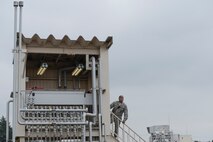 Staff Sgt. Trevor Alexis, 374th Civil Engineer Squadron fire protection NCO in charge of training, runs the gas lines to the fire training pit during live-fire training at Yokota Air Base, Japan, July 7, 2015. The training pit provided mock fires for the teams to extinguishing and the training allowed the members to hone their skills in fire elimination. (U.S. Air Force photo by Staff Sgt. Cody H. Ramirez/Released)