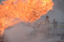 Members with the 374th Civil Engineer Squadron practice fire protection at Yokota Air Base, Japan, July 7, 2015. Fire protection members practiced extinguishing engine, running fuel and fuselage fires during their monthly training at the fire training pit. (U.S. Air Force photo by Staff Sgt. Cody H. Ramirez/Released)