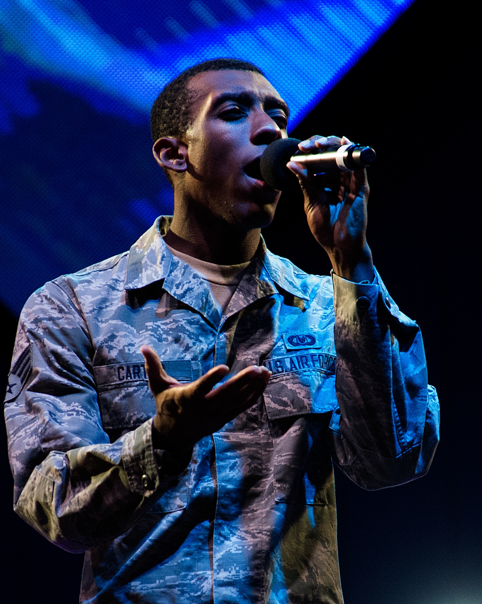 Senior Airman Rashaun Carter belts out a solo during a Fourth of July show by the tops in Blue, the U.S. Air Force premier entertainment group in the Cheyenne Frontier Days Arena in Cheyenne, Wyo., July 4, 2015. The troupe has provided Cheyenne’s prefireworks entertainment for four of the last five years. (U.S. Air Force photo by R.J. Oriez/Released)