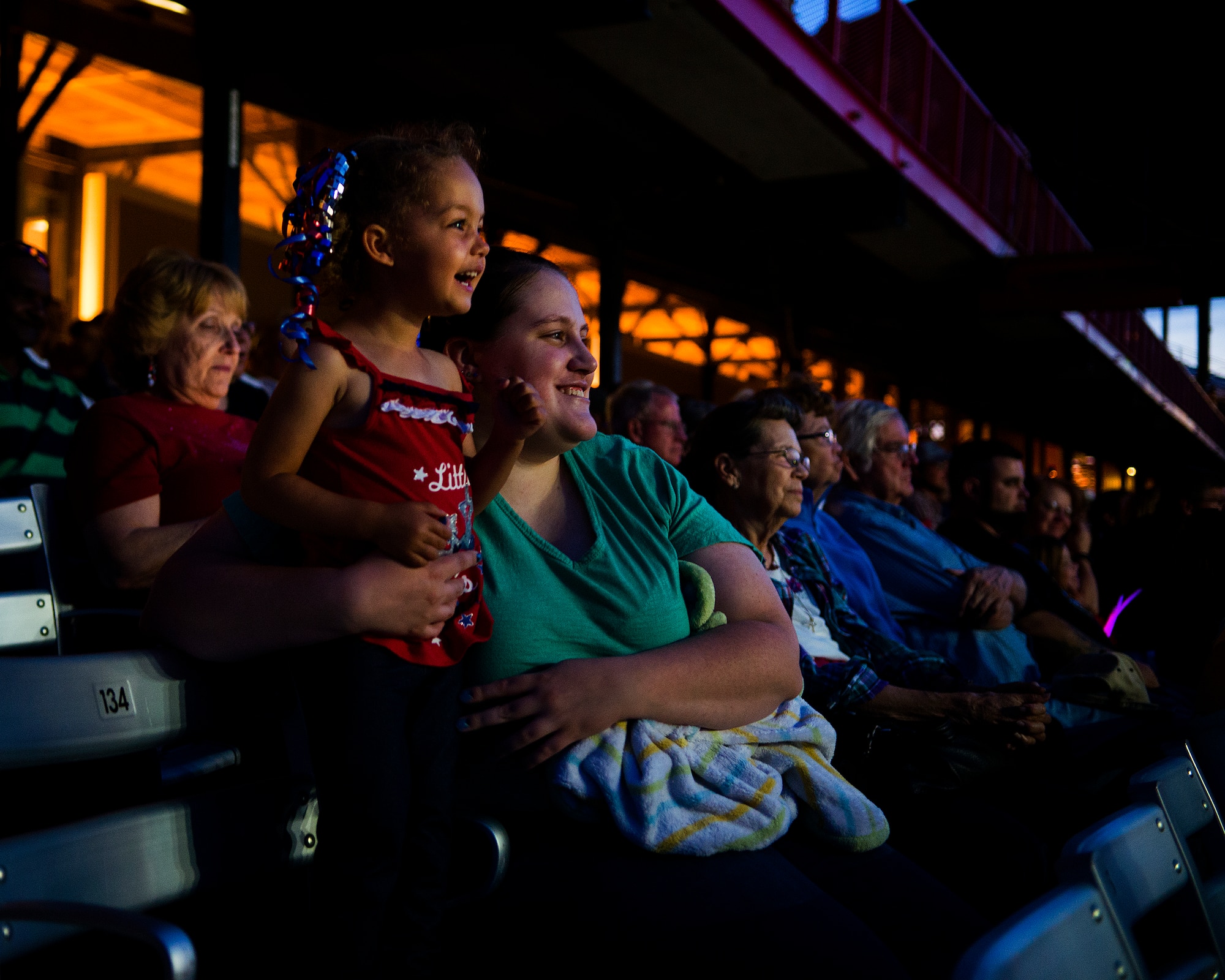 Khai-Lia Junk, 2, and her aunt, Sara Junk watch the Tops in Blues’ Independence Day show in the Cheyenne Frontier Days Arena, Cheyenne, Wyo., July 4, 2015. Khai-Lia is staying with her aunt while her mother, Staff Sgt. Brittany Junk, 90th Force Support Squadron, is deployed. (U.S. Air Force photo by R.J. Oriez/Released) 