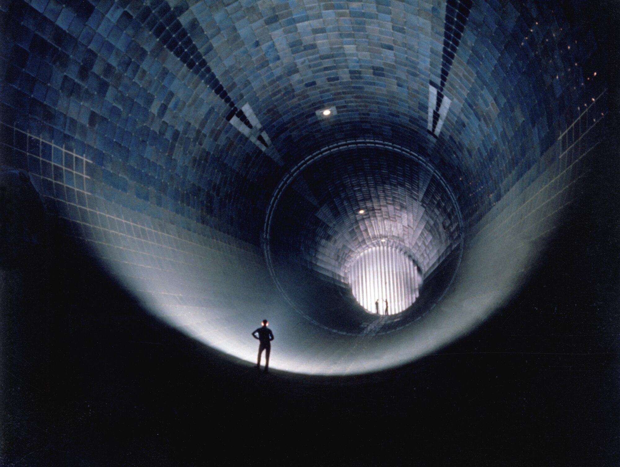 From left, Charlie Powell, in foreground, R. Pierson Smith and Bob Bomar, stand on turning vanes inside the Arnold Air Force Base Arnold Engineering Development Complex’s 16-foot supersonic wind tunnel test facility. Representatives from the Air Force Civil Engineer Center and several energy service companies recently conducted an energy savings performance contract site visit at the Tennessee base. (U.S. Air Force photo/Phil Tarver/Released)