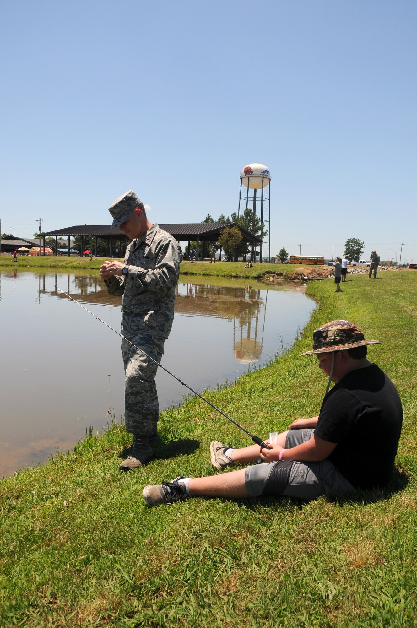 2nd Lt. Samuel Grounds, 188th Wing assistant executive officer, assists a student of the Alma School District with fishing at Ebbing Air National Guard Base, Ark., by fixing his line June 11, 2015. Students of the Alma School District that attend Camp Airedale were able to see the statics of the aircraft the 188th used in previous missions and sat in briefings about the 188th Wing’s current mission before fishing in Ebbing Lake. (U.S. Air National Guard photo by Senior Airman Cody Martin/Released)