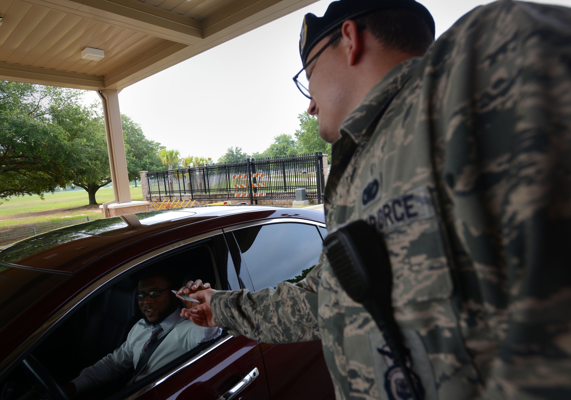 U.S. Air Force Senior Airman Sanchez Boyette, 20th Security Forces Squadron installation entry controller, returns an identification card at Shaw Air Force Base, S.C., July 1, 2015. The 20th SFS installation entry controllers ensure that only authorized personnel enter the base. (U.S. Air Force photo by Airman 1st Class Kelsey Tucker/Released)
