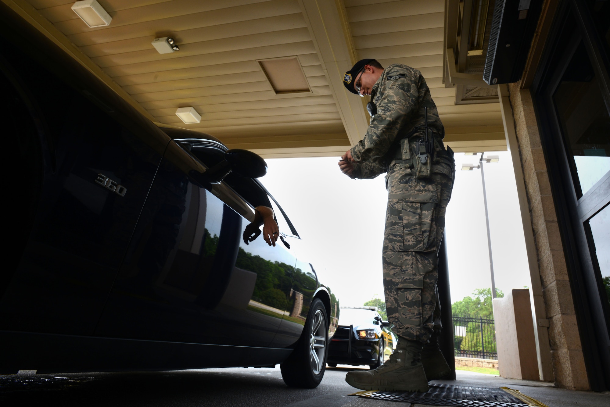 U.S. Air Force Senior Airman Sanchez Boyette, 20th Security Forces Squadron installation entry controller, checks identification cards at the main gate at Shaw Air Force Base, S.C., July 1, 2015. Boyette, who entered the Air Force in May 2009, has been a member of the 20th SFS since January 2015. (U.S. Air Force photo by Airman 1st Class Kelsey Tucker/Released)