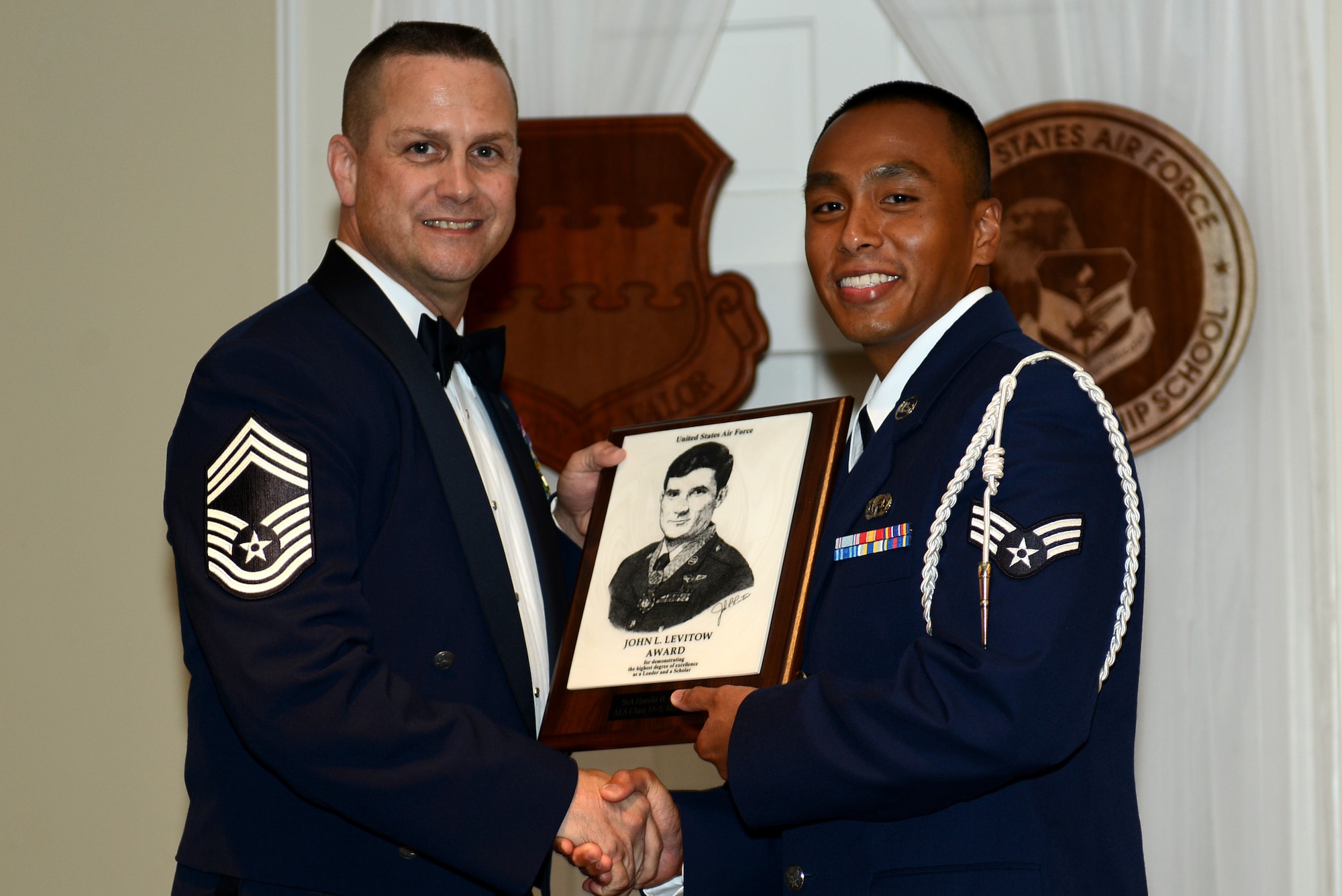 U.S. Air Force Senior Airman Harold Casenas, 31st Intelligence Squadron, receives the John L. Levitow Award for the Senior Master Sgt. David B. Reid Airman Leadership School Class 15-5, from Chief Master Sgt. Jason Tiek, 20th Maintenance Group superintendent, at Shaw Air Force Base, S.C., July 2, 2015. The Levitow Award is given to the graduate with the highest average of instructor and student points, and is the highest award in enlisted professional military education. (U.S. Air Force photo by Senior Airman Diana M. Cossaboom/Released)