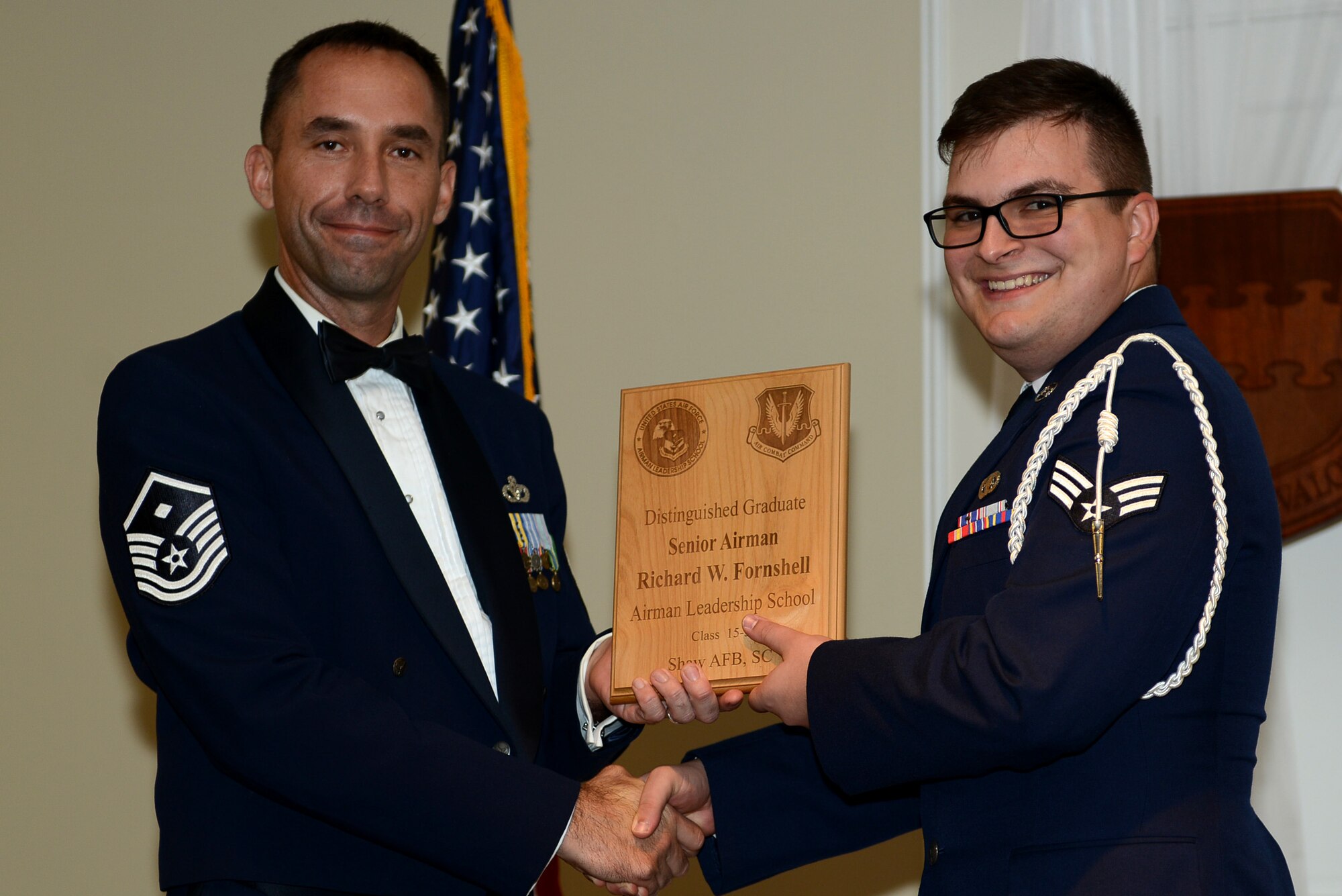 U.S. Air Force Senior Airman Richard Fornshell, 3rd Intelligence Squadron, receives a distinguished graduate award for the Senior Master Sgt. David B. Reid Airman Leadership School Class 15-5 from Master Sgt. Robert Finton, 20th Operations Support Squadron first sergeant, at Shaw Air Force Base, S.C., July 2, 2015. The distinguished graduate awards are given to the top 10 percent of the class for total point accumulation. (U.S. Air Force photo by Senior Airman Diana M. Cossaboom/Released)