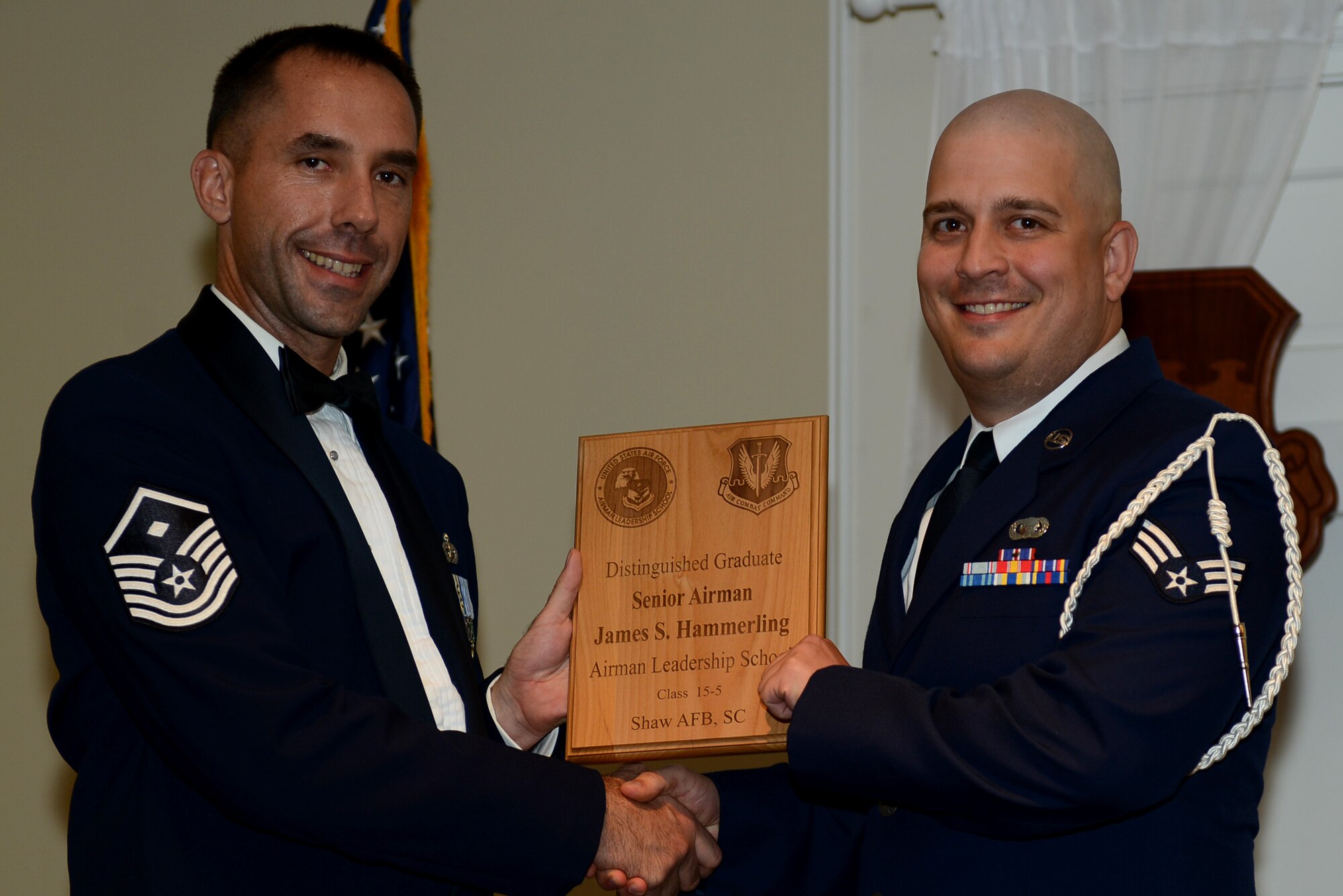 U.S. Air Force Senior Airman James Hammerling, 3rd Intelligence Squadron, receives a distinguished graduate award for the Senior Master Sgt. David B. Reid Airman Leadership School Class 15-5 from Master Sgt. Robert Finton, 20th Operations Support Squadron first sergeant, at Shaw Air Force Base, S.C., July 2, 2015. The distinguished graduate awards are given to the top 10 percent of the class for total point accumulation. (U.S. Air Force photo by Senior Airman Diana M. Cossaboom/Released)