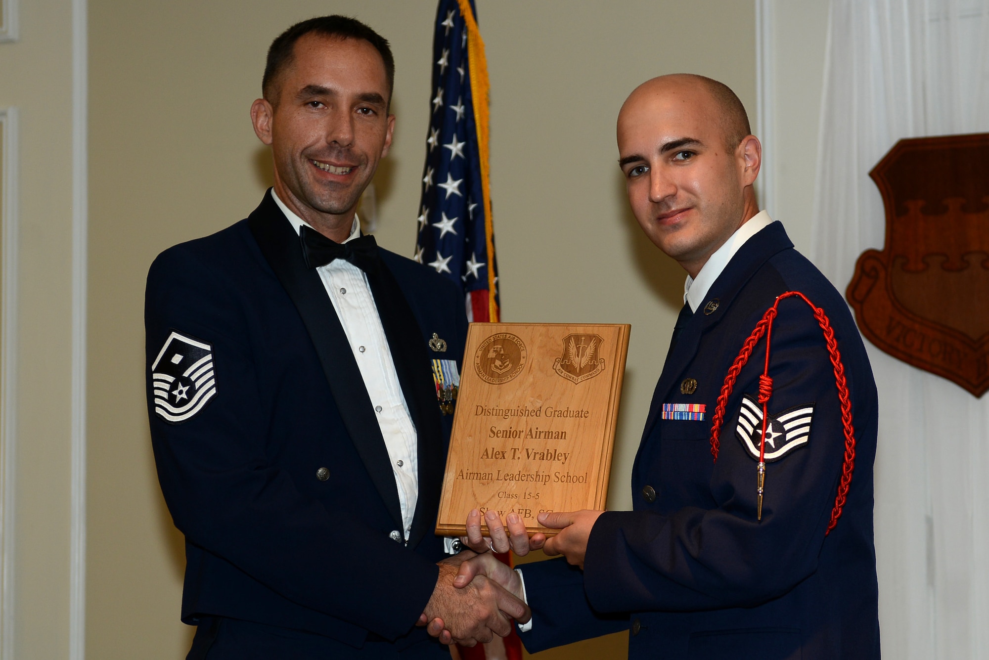 U.S. Air Force Staff Sgt. Alex Vrabely, 31st Intelligence Squadron, receives a distinguished graduate award for the Senior Master Sgt. David B. Reid Airman Leadership School Class 15-5 from Master Sgt. Robert Finton, 20th Operations Support Squadron first sergeant, at Shaw Air Force Base, S.C., July 2, 2015. The distinguished graduate awards are given to the top 10 percent of the class for total point accumulation. (U.S. Air Force photo by Senior Airman Diana M. Cossaboom/Released)